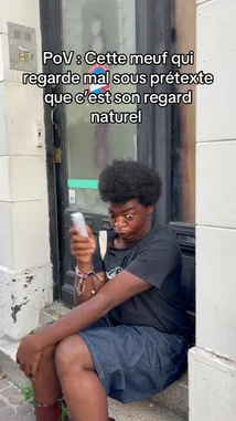 A man with a large afro sits outside, looking directly at the camera with a confused expression. Text overlay reads 'POV: This guy who looks bad under the pretext that it's his natural look.' He then gestures towards his hair while speaking, seemingly in a comedic defense of his hairstyle. by @prmecc with Original Sound by prmecc