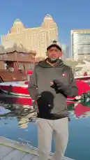 Join Alkasus 🦅 on a scenic walk along the Dubai Marina waterfront. In this vlog-style clip, he showcases the stunning city skyline, luxury yachts, and traditional wooden boats under a clear blue sky. He speaks directly to the camera while gesturing towards the impressive backdrop, offering a personal perspective on this iconic location. by @bakame01 with bakame01 by Original Sound