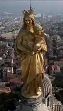 This aerial video showcases the stunning golden statue of the Virgin Mary atop the Notre Dame de la Garde basilica in Marseille, France. The camera gracefully pans around the monument, revealing its impressive architecture and offering sweeping views of the city's red-tiled rooftops, the bustling harbor filled with boats, and the Mediterranean coastline stretching into the distance. by @omofficial with Original Sound by Contains: Sensations - JUL