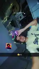 A person in a dimly lit room with string lights and a gaming setup makes a hand gesture towards the camera during a live stream. The text 'LIVE THE MOMENT' is overlaid on the screen. A small picture-in-picture window shows another user, while emojis like 😂🎮 appear at the bottom. by @lil.ishhhh with Original Sound by Contains: SugarCrash! - Elyotto