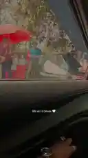 This short clip captures a moment inside a car during the morning hours. The camera pans across the interior, showing the dashboard, steering wheel, and navigation screen, before focusing on the view through the windshield. Outside, people can be seen under an umbrella near a fence, suggesting a casual, everyday setting. by @devpathakjiii with Original Sound by devpathakjiii