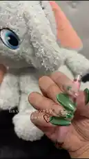 오리지널 사운드 포함 @la_kari365 님이 만든 In this charming clip, Kari showcases her festive green nail art adorned with shamrocks and glitter, holding a pink pen. A soft, grey stuffed elephant with large blue eyes sits beside her. Text on screen reads 'have a lovely Monday' with a heart emoji, creating a sweet and positive start-of-the-week vibe perfect for social sharing.
