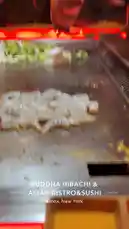 dassweenbean 님이 만든 Original Sound 포함 @dassweenbean 님이 만든 A chef at Buddha Hibachi & Asian Bistro in the Bronx performs a dramatic teppanyaki cooking show. Raw shrimp sizzle on the hot griddle while vegetables are prepared nearby. The scene culminates in a spectacular flame burst over a piece of onion, showcasing the skill and entertainment value of live hibachi dining.