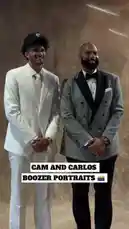 In a behind-the-scenes look at a professional photoshoot, an NBA player in a sharp white suit poses alongside a celebrity coach in a stylish plaid tuxedo. The pair share a moment of camaraderie, smiling and interacting warmly under studio lights before shaking hands. This candid moment captures the blend of athletic fame and polished style. by @nba with Original Sound by nba
