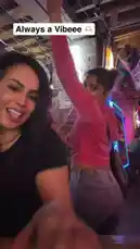 This energetic clip captures two women enjoying themselves at a lively bar. One woman films a selfie video while her friend dances enthusiastically behind her. They share drinks and make playful faces for the camera, creating a fun and spontaneous moment. The background features other patrons and vibrant neon lights, adding to the festive atmosphere. by @e-beth with Original Sound by e-beth