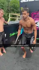 A shirtless man performs a daring jump into a body of water while holding two large barbell weights. He leaps from a platform, creating a massive splash upon impact. The scene captures the full stunt from preparation to entry, showcasing strength and athleticism. by @digiflips with Original Sound by digiflips