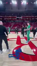 The Boston Celtics warm up on the court during a practice session at the Toyota Center. Players in green tracksuits engage in drills and shooting exercises under bright arena lights, preparing for their upcoming game. The atmosphere is energetic as teammates pass and shoot, showcasing their focus ahead of a major NBA matchup. by @celtics with Original Sound by celtics