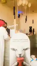This festive scene captures the spirit of Eid Al Adha at FOX Café, where a charming sheep-themed promotional display takes center stage. Guests in traditional attire mingle under elegant balloon decorations, creating a warm and inviting atmosphere for the holiday celebration. by @fox_cofee with original sound