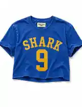This video showcases a vibrant blue cropped t-shirt featuring bold yellow text that reads 'SHARK' above the number '9'. The design is reminiscent of a sports jersey, suggesting a connection to team culture or a personal brand. The shirt is displayed against a plain background, highlighting its graphic details and style. by @mts550 with original sound