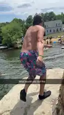 A shirtless man wearing patterned swim trunks stands on a large rock overlooking a lake crowded with people and boats. He takes a moment before launching himself into a backflip, successfully landing in the water with a splash. by @digiflips with Original Sound by digiflips
