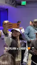 WNBA star Kehlani shares a joyful moment with her fan Gabby backstage after a game. They take selfies together, smile for the camera, and interact warmly with other people in the background, capturing a candid and friendly post-game celebration. by @wnba with Original Sound by wnba
