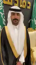 In this engaging clip, Khalifa Eid, dressed in a traditional black bisht with gold trim over a white thobe and ghutra, addresses the camera directly from an elegant room adorned with Saudi Arabian flags and golden calligraphy. His expressive hand gestures and confident delivery suggest he is sharing a personal story, offering advice, or making an announcement. This authentic moment captures his presence and style. by @kh-p19 with kh-p19 by Original Sound