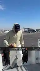 A man presumed to be an LA Clippers player walks off an airplane tarmac, pulling a rolling suitcase and carrying a drink. The sunny day and airport setting suggest a team travel moment, offering fans a glimpse behind the scenes. by @clippers with Original Sound by clippers