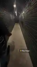 itsma_bitchezz 님이 만든 Original Sound 포함 @itsma_bitchezz 님이 만든 A person walks through a narrow, dimly lit tunnel with dark brick walls. They are holding a walkie-talkie and speaking into it. The tunnel has text written on the wall, and the person appears to be exploring or communicating while moving forward.