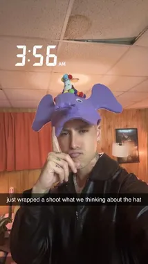 In this candid behind-the-scenes look, music artist Jez Dior shares his creative process after wrapping a photoshoot. Wearing a playful purple elephant hat with colorful pom-poms, he reflects on the experience in a casual indoor setting. The footage captures a moment of post-production thoughtfulness, offering fans an intimate glimpse into his artistic journey. by @jezdior with original sound