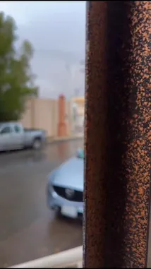 This atmospheric clip captures the aftermath of a sudden rainstorm in a residential area of Abu Dhabi. Viewers see wet streets reflecting the dramatic sky, parked cars like a silver Mazda CX-5, and lush green trees, all under a moody, overcast sky. The scene evokes a sense of calm and tranquility after the weather has passed. by @karim.alsaleh with 🌂⛈️ Winter in Hail by «عسـاه ينثـر من فـوق حايـل همـاليـل»