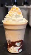 A close-up shot of a Starbucks pumpkin spice frappuccino topped with whipped cream and crumbled cookie pieces. The drink features a layered appearance with coffee, milk, and chocolate syrup. This visually rich beverage is presented as part of a review or recipe demonstration. by @mts550 with original sound