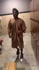Delly is in a locker room, smiling and posing for the camera while wearing a robe. He then walks towards the shower area, still in good spirits. by @delwinbazilme with My Brother by BtherGangVonnie