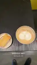 오리지널 사운드 포함 @tufavlatiino 님이 만든 A top-down view captures a beautifully crafted latte with intricate cat-shaped foam art alongside a classic biscotti cookie. The scene, set on a dark wooden table in Sunnyvale, CA, evokes a peaceful café experience. This moment, shared by Yohan, is perfect for coffee lovers and latte art enthusiasts.