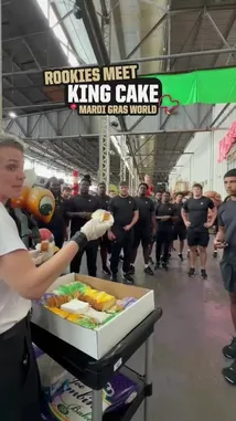 In a festive behind-the-scenes look at Mardi Gras preparations, a group of New Orleans Saints players gather to celebrate the tradition of receiving the King Cake. A woman hands out slices of the colorful cake to the team members, including rookie Jeremiah Wright, who proudly displays his slice after finding the hidden plastic baby inside. The moment is captured with humor and camaraderie, showcasing a beloved cultural ritual before the team's big game. by @saints with Original Sound by saints