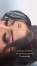 A close-up shot captures a person with sleek, dark hair styled away from the face, showcasing bold, defined eyebrows and dramatic smoky eye makeup with shimmery pink and purple tones. The static, artistic composition highlights the details of the professional-looking beauty look. by @batoolmakeup1 with السلام عليك 🌚. by 🏃🏻‍♂️🏃🏻‍♂️.