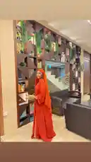 In this stylish moment, Everything Naddy showcases a stunning red hijab and matching traditional outfit in a chic, modern interior. The setting features a unique geometric wall with lush greenery and contemporary wicker furniture, creating a perfect backdrop for her look. by @everythingnaddy with she go by💃 by Contains: she goes by. (KayArchon Remix) - KayArchonn & where.t.at