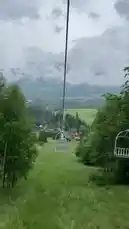 Experience the serene beauty of a chairlift journey through lush green hills and fog-covered mountain peaks. This tranquil ride offers breathtaking panoramic views of a valley dotted with houses and forests, capturing the essence of peaceful mountain travel. by @sahab-alalam with sahab-alalam by Original Sound