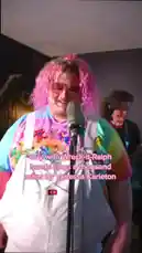 Witness a stunning live performance of Vanessa Carlton's 'A Thousand Miles' by a fan dressed as Wreck-It Ralph. This captivating singer, sporting a vibrant pink wig and a colorful tie-dye shirt under white overalls, delivers an energetic and heartfelt rendition of the classic song. The full cosplay includes iconic glasses, bringing the beloved character to life while showcasing incredible vocal talent. by @iamtalk with iamtalk by Original Sound