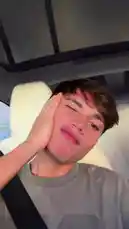 A young man, identified as S E B A S 🧸, films himself in a car, showcasing his style with a casual grey t-shirt and seatbelt. He playfully poses for the camera, runs his hands through his hair, and shares a moment of connection during a phone call, creating a relatable and personal vlog experience. by @twinksebass with Original Sound by Contains: See You Again - Tyler, The Creator feat. Kali Uchis