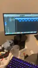 In this behind-the-scenes look, music producer Da First Option ⚡️ reveals his digital audio workstation (DAW) in real-time. The camera focuses on a computer monitor displaying a complex music track with multiple blue audio clips arranged on a timeline, while his arm rests casually on the desk beside it. This intimate shot provides a glimpse into his creative process. by @nascarfeezy with Original Sound by nascarfeezy