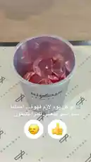A close-up view of Sequence Coffee's signature drink being prepared. Clear liquid is poured into a silver cup filled with ice and red fruit pieces, creating a vibrant pink beverage with a frothy top. The cup sits on branded 'SEQUENCE' paper, showcasing the coffee shop's aesthetic. by @sequence-coffee with Original Sound by sequence-coffee