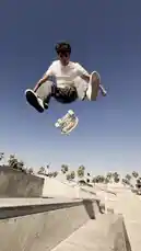 This dynamic video captures a skateboarder performing tricks in a vibrant urban setting. It begins with a close-up of the skater preparing to launch off a concrete ledge. The scene transitions to a wide shot showing the skater executing a jump over a metal rail, set against a backdrop of palm trees and a clear blue sky. An aerial view reveals the surrounding area, including a tennis court and a building adorned with a large mural. The skater then rides alongside the mural, which features the text 'SPECS we believe' and illustrations of aliens. The video concludes with a focus on the mural, highlighting the iconic Santa Monica Pier and Ferris wheel in the background. The energetic music complements the fluid motion of the skateboarding, creating an engaging visual experience. by @specs with Original Sound by specs