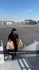 A player associated with the LA Clippers is seen walking down the stairs of an airplane on a sunny day. He carries multiple shopping bags, including a prominent Chick-fil-A paper bag, suggesting he's either arriving from or departing for a trip. The scene captures a candid moment of a professional athlete's life away from the court. by @clippers with Original Sound by clippers