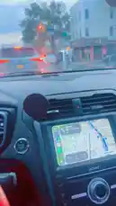 abdoufall205962 님이 만든 Original Sound 포함 @abdoufall205962 님이 만든 A driver's perspective view from inside a car during a rainy day commute. The dashboard features a Sony navigation screen displaying a route through city streets. Raindrops cover the windshield, and the red steering wheel adds a pop of color to the scene. The car moves slowly through traffic, with taillights visible ahead, creating a moody and atmospheric urban driving experience.