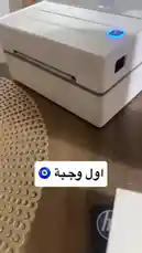 This short tutorial demonstrates the process of using a compact thermal printer to create shipping labels. It shows the printer in action, printing a label with a barcode and text, and then dispensing it onto a wooden desk. The clear, step-by-step visual guide makes it easy to understand how to operate this device. by @semsemallc25 with ماشاء الله😍🖐🏽 by jaber1991**