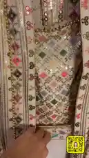 A stunning traditional bridal outfit is elegantly displayed on a mannequin. The camera slowly pulls back to reveal the full ensemble, which includes a heavily embellished lehenga choli with intricate mirror work and sequins, paired with a sheer, long-sleeved dupatta featuring floral patterns. The garment's craftsmanship highlights the artistry of 'إبرة و خيط🧵🪡'. This visual showcase is perfect for anyone interested in Indian wedding attire, fashion design, or textile art. by @needle_t with original sound