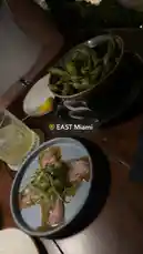 오리지널 사운드 포함 @itsma_bitchezz 님이 만든 A close-up view of a beautifully plated dish featuring seared tuna with a vibrant green garnish, accompanied by a bowl of fresh edamame. The setting suggests an intimate dinner at EAST Miami, capturing the essence of modern dining and culinary artistry.