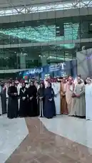 Witness a formal gathering at the National Date and Palm Conference in Saudi Arabia. This event brings together key figures, including men in traditional thobes and women in elegant abayas, for what appears to be an official opening ceremony or panel discussion. The modern venue, adorned with banners for 'Sooq Al-Nakheel' and 'Al-Nakheel Market,' highlights the intersection of cultural heritage and contemporary business in the kingdom's vital date industry. by @ncpd.sa with Original Sound by ncpd.sa