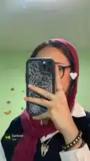 In this stylish self-portrait, Hanah demonstrates a modern hijab look perfect for everyday wear. She pairs a vibrant magenta hijab with a chic black blazer, white collared shirt, and statement jewelry. Her phone case features a striking spiderweb design, adding an edgy touch to her outfit. This look is ideal for anyone seeking inspiration on how to style a hijab for a fashionable yet modest appearance. by @inxhell with Cacharel by Contains: Cacharel - Akher Zapheer