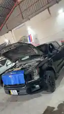 This video shows a black Ford F-150 pickup truck with its hood open inside a well-lit auto repair garage. Another vehicle is visible in the background, also undergoing maintenance. The setting suggests a professional automotive service environment. by @hawkar_service with Original Sound by hawkar_service