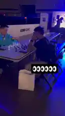 Witness a high-stakes chess tournament in progress, where two players are locked in deep concentration over a complex game. The atmosphere is electric under dramatic blue lighting, with a large screen in the background displaying live commentary and scores. This intense battle of wits showcases the strategic depth and mental focus required at the highest levels of competitive chess. by @chesscom with Original Sound by chesscom