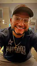 In this selfie-style clip, Tomas Guerrero showcases his personal style with a Dallas Cowboys t-shirt, gold cross necklace, and signature glasses. He smiles warmly at the camera, giving viewers a glimpse into his casual, confident everyday look. by @tomasg3901 with original sound