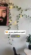 This static shot captures the stylish interior of a café or lounge space. A prominent feature is a large portrait of a man wearing a traditional red-and-white patterned keffiyeh and agal. The wall is decorated with cascading green ivy and warm, glowing fairy lights, creating a cozy ambiance. In the foreground, a small round table holds a potted plant and a black chair. A Snapchat story sticker for 'أهلاً رضمان' is visible, suggesting this is a social media post from the 'Proteinz' brand, which focuses on healthy meals. by @proteinz_sa with 🌙اهلاً رمضان by بروتينز
