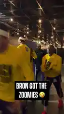 Watch LeBron James and the LA Lakers team during an intense practice session. The players, dressed in bright yellow 'BLACK HISTORY' shirts, are seen running drills and warming up in their practice facility. One player is featured prominently performing a dynamic sprint drill, showcasing his speed and agility. Text overlays like 'BRON GOT THE ZOOMIES 😂' highlight the fun and energetic atmosphere of the team's training routine. by @lakerssnaps with Original Sound by lakerssnaps