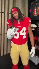 A series of San Francisco 49ers players, including those wearing jerseys #54, #85, #44, #20, #69, #1, #35, and #94, are shown in a locker room setting reacting with excitement and surprise upon receiving a text message on their phones. The players look at their phones, talk about the message, and share the moment with each other, creating a fun and energetic team atmosphere. by @sf49ers with Original Sound by sf49ers