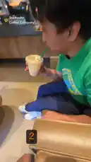 itsma_bitchezz 님이 만든 Original Sound 포함 @itsma_bitchezz 님이 만든 In a casual moment at a Starbucks Coffee Company, Diana V enjoys a light-colored iced beverage through a green straw. She is wearing a vibrant green t-shirt with a blue fish logo and the word 'EXPECTATIONS', paired with dark blue pants. A '#PSL' hashtag is overlaid on the screen, suggesting a connection to the popular Pumpkin Spice Latte season.