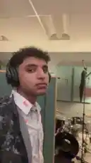 A behind-the-scenes look inside a recording studio features musician K-DEV wearing headphones and a patterned shirt. He sings into a microphone while gesturing expressively, showcasing his creative process. by @k_dev170 with Original Sound by k_dev170