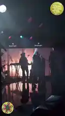 A dynamic live concert performance by singer Sabrina Carpenter at the Daisy Chain Fields Music Festival. She sings passionately into a microphone, wearing a long black dress and layered necklaces, under dramatic stage lighting. Her band, including a drummer and guitarists, accompanies her on a reflective stage. The audience is visible in silhouette, enjoying the energetic show. by @daisychainfield with Original Sound by Contains: The Lighthouse - Stevie Nicks