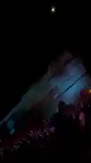 A breathtaking night scene unfolds at Red Rocks Amphitheatre as a massive crowd gathers beneath the iconic sandstone formations. Illuminated by dramatic blue lighting, the rock face glows under a bright moon, creating a magical atmosphere. This stunning moment, captured by Sasha, showcases the venue's natural beauty during a live event. by @squashha with squashha by Original Sound