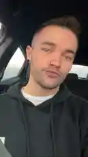 In this short, candid clip, Kenneth takes a selfie from inside his car. He looks directly at the camera with a playful expression, showcasing his modern style including a nose ring and ear gauges. The natural light from the window suggests it's daytime, creating a relaxed and personal atmosphere. This authentic moment captures a slice of everyday life, perfect for fans wanting to connect with Kenneth beyond curated content. by @ken_sutton23 with original sound